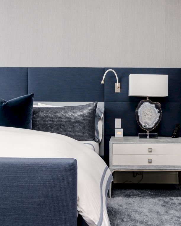 Elegant bedroom with a blue and white theme, modern furnishings, and decorative items